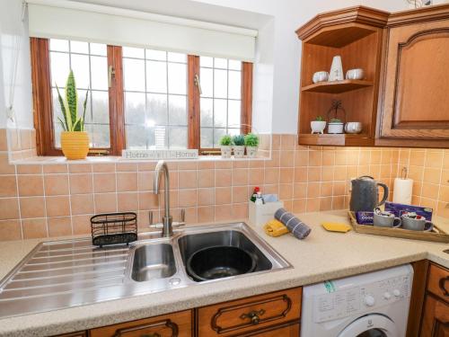 a kitchen with a sink and a dishwasher at Condicote Cottage in Weston on Avon