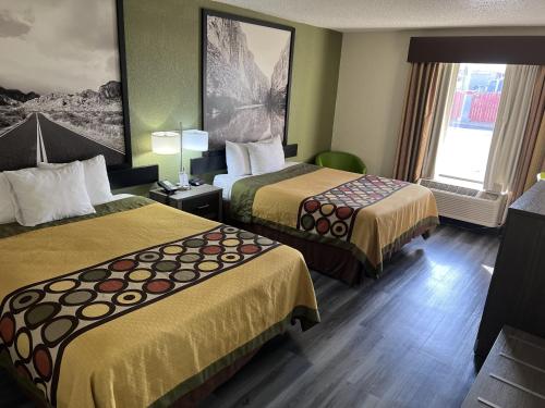 a hotel room with two beds and a window at Super 8 by Wyndham Ft Stockton in Fort Stockton