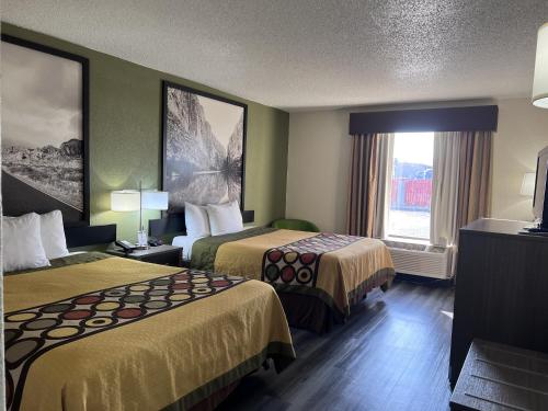 a hotel room with two beds and a window at Super 8 by Wyndham Ft Stockton in Fort Stockton