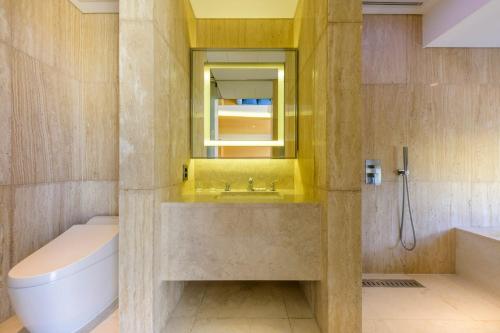 a bathroom with a sink and a tub and a mirror at STANFORD Hotel & Resort Jeju in Jeju