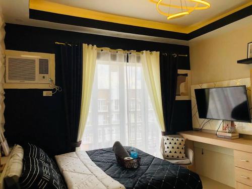 1 dormitorio con 1 cama y ventana grande en Azehr's Walk Up and Cozy Condo en Minglanilla