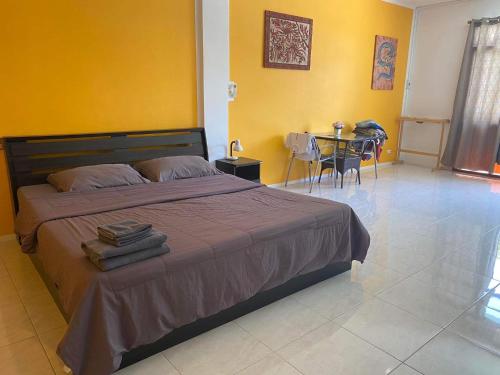 een slaapkamer met een bed en een tafel met stoelen bij Da Puccio Rawai Guesthouse in Rawai Beach