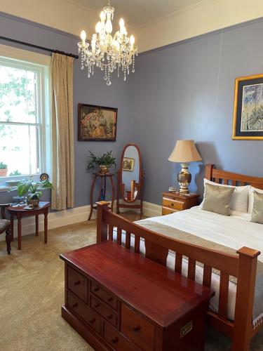 um quarto com uma cama grande e um lustre em Leconfield House em Greta