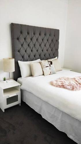 Katil atau katil-katil dalam bilik di Stylish Spacious Auburn 3Bedroom House Near Olympic Park ANZ Stadium DFO Pet Friendly