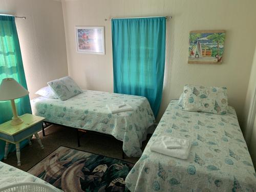 a room with two beds and a table with a lamp at Queen Anne's Revenge at the Beach cottage in Kitty Hawk