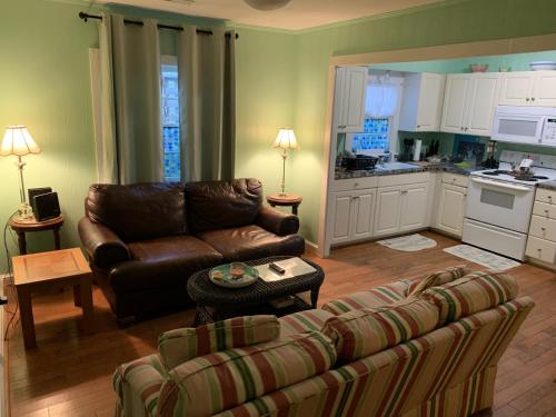 a living room with a couch and a kitchen at Queen Anne's Revenge at the Beach cottage in Kitty Hawk