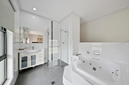 a white bathroom with a tub and a sink at Talga Estate in Lovedale
