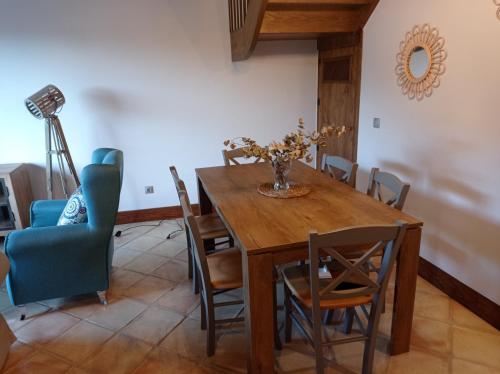 uma sala de jantar com uma mesa de madeira e cadeiras em Casa con encanto en La Hayuela, situada a 5 min de Comillas em Udias