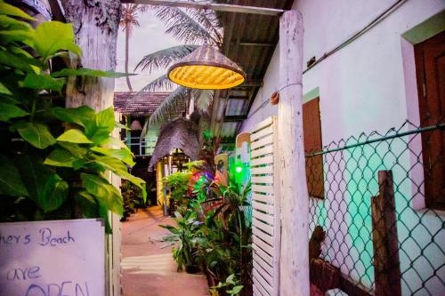 a light hanging from the side of a building with plants at Brother's Beach Home in Galle