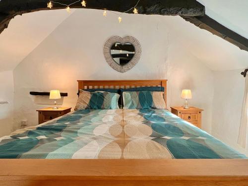 a bedroom with a large bed with two lamps at Easterly Cottage in Bude
