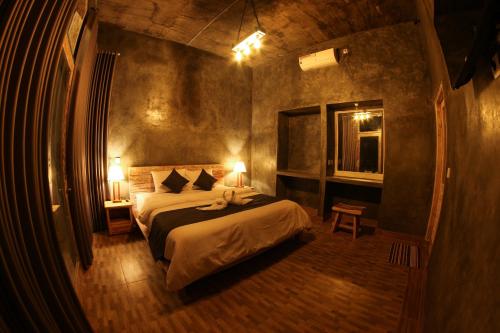 a bedroom with a bed and a window and two lamps at KATON HILLS in Nusa Penida
