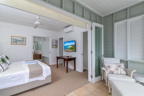 een slaapkamer met een bed, een bank en een tafel bij Seascape Holidays Villas on Murphy Street in Port Douglas