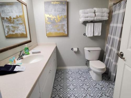 a white bathroom with a toilet and a sink at Beautiful one bedroom oceanfront condo in Daytona Beach
