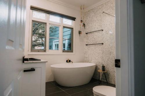 eine weiße Badewanne im Bad mit Fenster in der Unterkunft Parkside in Blackheath