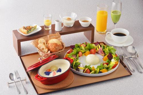 a breakfast tray with a plate of food and a salad at Villa Concordia Resort & Spa in Hakodate