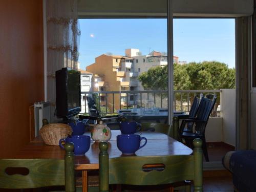 une table de salle à manger avec vue sur un balcon dans l'établissement Cap d'Agde: Studio cabine 4 pers, piscine, plage à 600m, parking - FR-1-249-6, au Cap d'Agde
