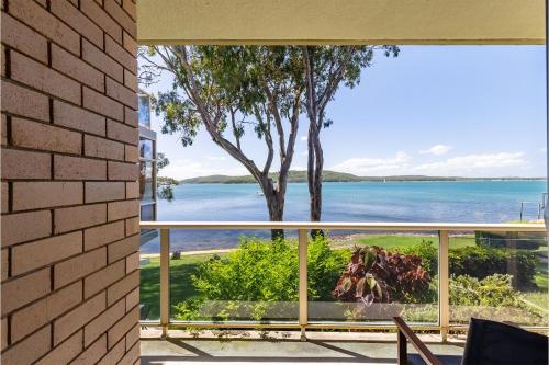 a view of the water from the balcony of a house at Kooringal 6, 105 Soldiers Point Rd - waterfront unit in Soldiers Point