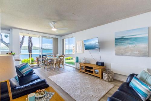 a living room with a couch and a table at Kooringal 6, 105 Soldiers Point Rd - waterfront unit in Soldiers Point