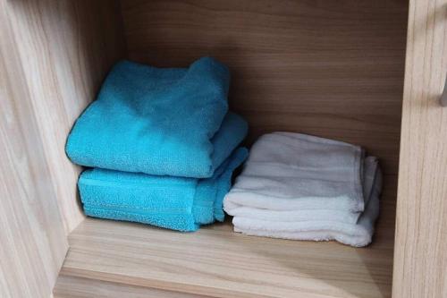 Dos toallas están apiladas en un armario de madera. en CityView Condo with balcony-12, en Cagayan de Oro