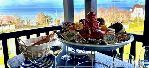 - un bol de nourriture assis sur une table avec des verres à vin dans l'établissement Appart lumineux avec vue sur mer à 180 degrés, à Trouville-sur-Mer