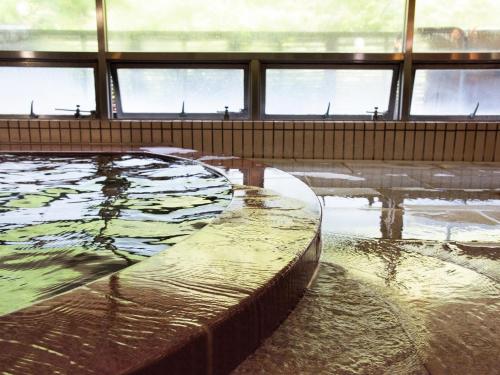 a large pool of water in a building with windows at Shin Kabakawa Kanko Hotel in Takamatsu