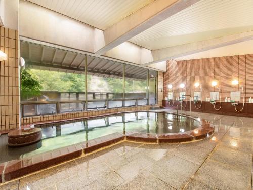 une piscine au milieu d'un bâtiment dans l'établissement Shin Kabakawa Kanko Hotel, à Takamatsu