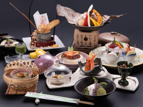 a table with plates of food on a table at Shin Kabakawa Kanko Hotel in Takamatsu