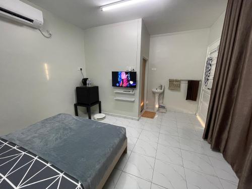 a bedroom with a bed and a flat screen tv at Aufa Roomstay in Pendang