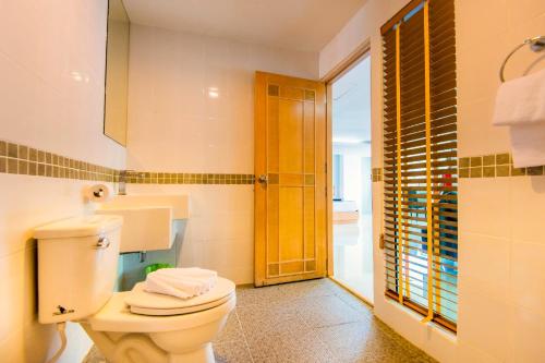 a bathroom with a white toilet and a shower at Hallo Patong Hotel in Patong Beach