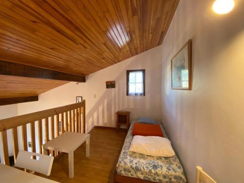 une petite pièce avec un lit et une table dans l'établissement Maison cosy 5 pers proche plage avec jardin, animaux admis - FR-1-413-120, à Capbreton