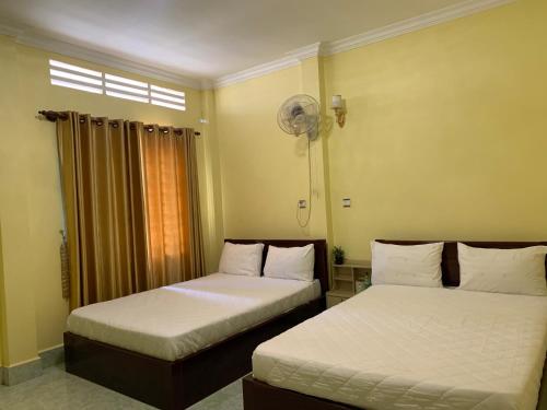 1 dormitorio con 2 camas y ventilador en HeangKanha GuestHouse, en Phumĭ Chŏng Kaôh