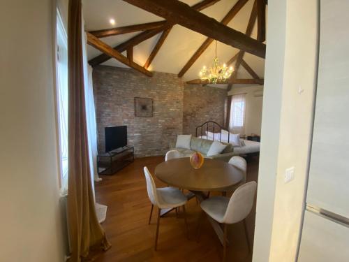 a dining room with a table and chairs in a room at DUOMO Murano Apartment with Canal view in Murano