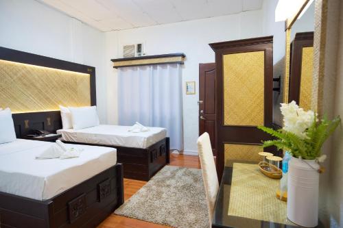 塔比拉蘭的住宿－道戴夢得餐廳及酒店，酒店客房设有两张床和一张桌子,桌子上配有四柱床。