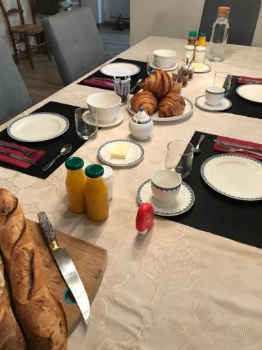 un tavolo con piatti di cibo e pane sopra di LA CHARMILLE Gîte et Chambre d'hôtes a La Copechagnière