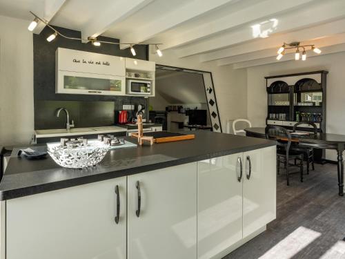 une cuisine avec des armoires blanches et un comptoir noir dans l'établissement Stunning 4-Bed House in La Bourboule, à La Bourboule