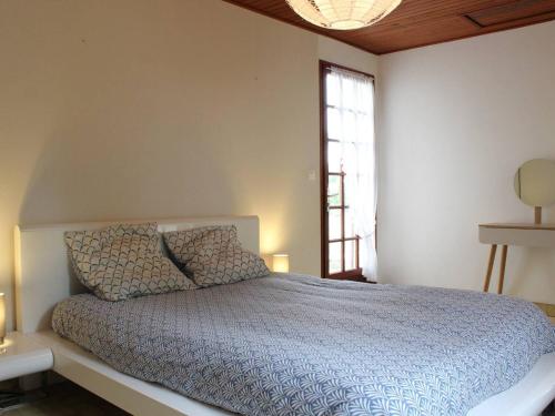 une chambre avec un lit avec une couette bleue et une fenêtre dans l'établissement Maison de vacances plage et forêt à Saint-Georges-d'Oléron – 6 couchages, jardin, terrasse, WIFI - FR-1-246A-80, à Saint-Georges-dʼOléron