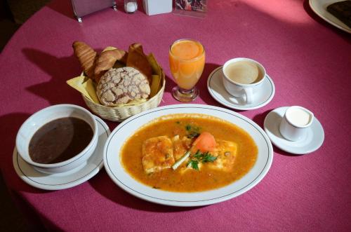 een tafel met een kom soep en een mand brood bij Hotel Casa Antigua in Oaxaca City