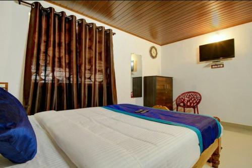 um quarto com uma cama e uma televisão num quarto em Hill View Homestay Madikeri Coorg em Madikeri
