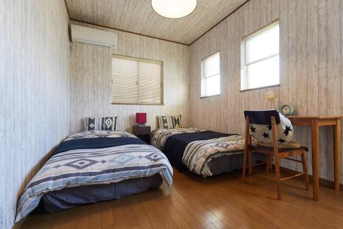 um quarto com duas camas e uma cadeira. em Seaside House Enoshima 江ノ島, Free Parking 漫居湘南海岸, 尋訪灌籃高手 em Koshigoe