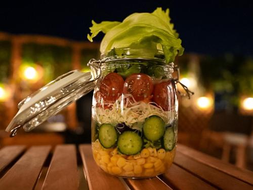 a jar filled with food and vegetables on a table at リバーサイドグランピングNuts in Higashiomi