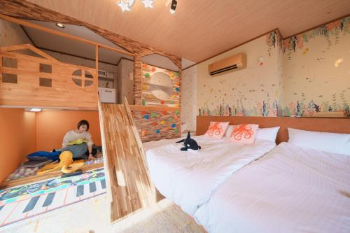a man sitting on a bunk bed in a bedroom at Diamond・Yu　Atami in Ajiro