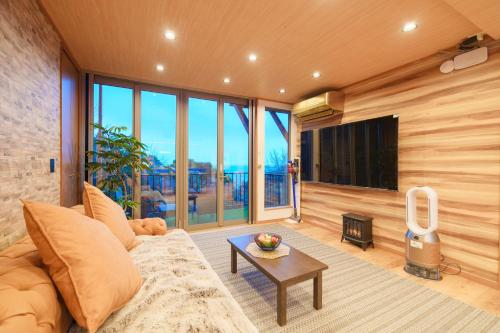 a living room with a couch and a tv at Diamond・Yu　Atami in Ajiro
