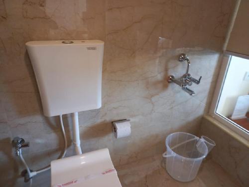 a bathroom with a toilet paper dispenser on the wall at Hotel Royal Chola in Kanchipuram