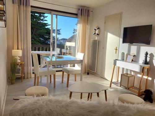 un salon avec une table, des chaises et une télévision dans l'établissement Studio Cabine 4 Pers, Front de Mer, Balcon Sud, Parking Privé, Vélos Inclus, Aucun Animal Autorisé - FR-1-465-84, à Merville-Franceville-Plage