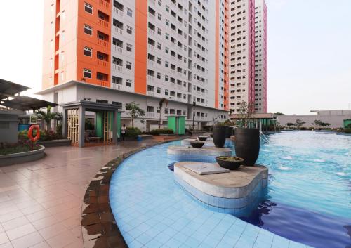 ein großes Schwimmbad in einer Stadt mit hohen Gebäuden in der Unterkunft Apartemen Green Pramuka City in Jakarta