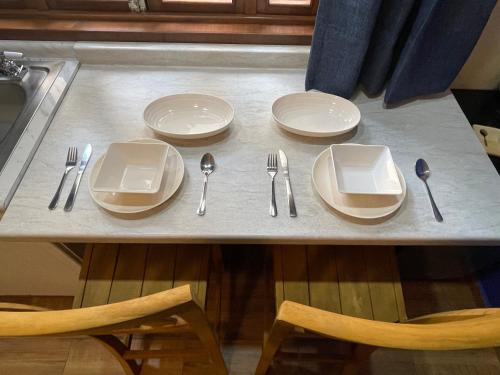 a table with plates and utensils on it at Casa El Arte de Frida in San Miguel de Allende
