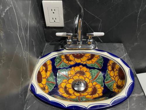 um lavatório de casa de banho com um padrão de flores em Casa El Arte de Frida em San Miguel de Allende