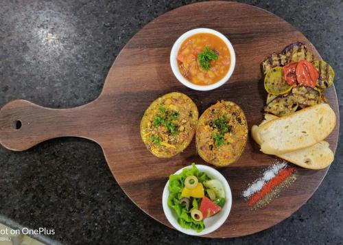 a wooden plate of food with bread and dips at Hotel Polo Towers Shillong in Shillong