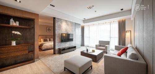 un soggiorno con un divano e un letto di Yun Estate Hotel a Tamsui