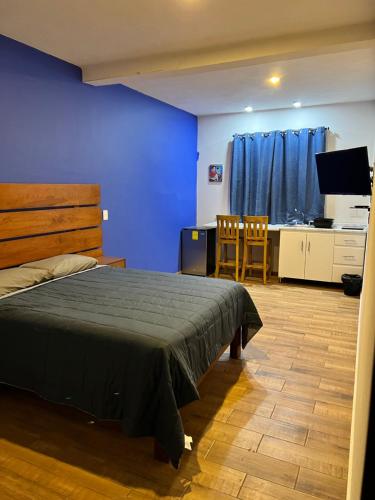 a bedroom with a bed and a table and a kitchen at Casa El Arte de Frida in San Miguel de Allende